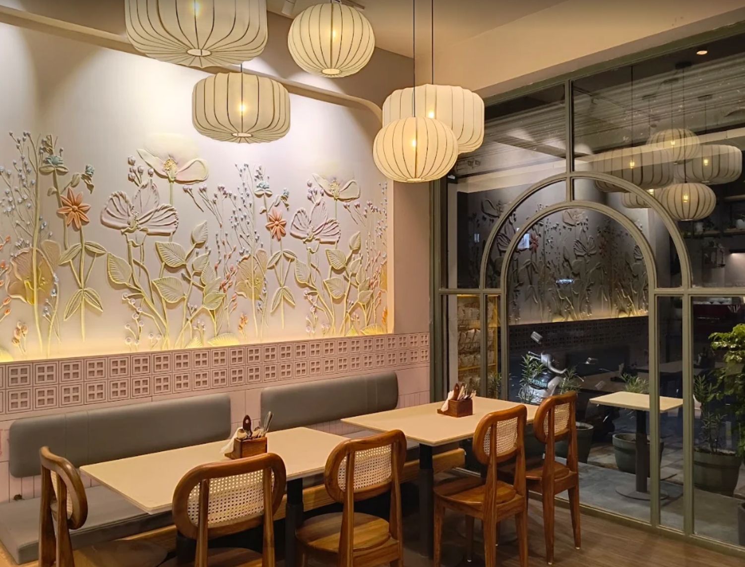 Floral relief wall, paper lanterns and cane chairs at Cafe Dolcezza